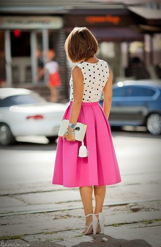 Бело-черный топ без рукавов в горошек и ярко-розовую юбку-миди со складками можно надеть как на работу, так на прогулку. Чтобы добавить в образ немного непринужденности, на ноги можно надеть белая обувь.