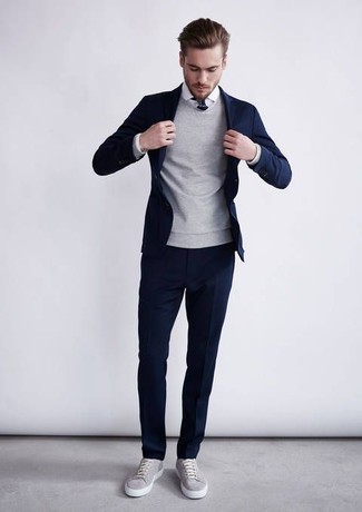 Темно-синий костюм и серый свитер с круглым вырезом — необходимые вещи в классическом мужском гардеробе. Что касается обуви, можно отдать предпочтение комфорту и выбрать серые кеды.