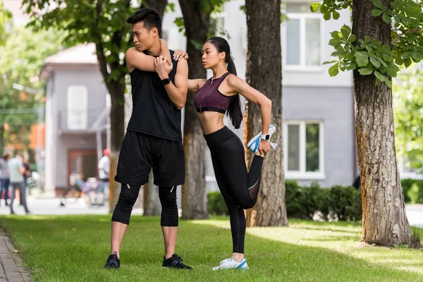 Young Asian Sportsman Sportswoman Stretching Grass Park — стоковое фото