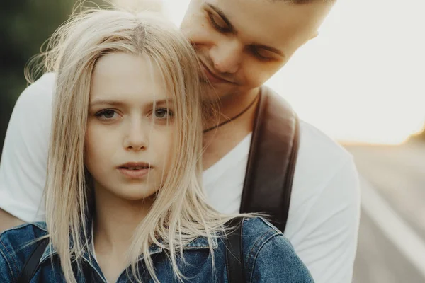 Smiling Young Man Embracing Beautiful Girlfriend Back While Standing Road — стоковое фото